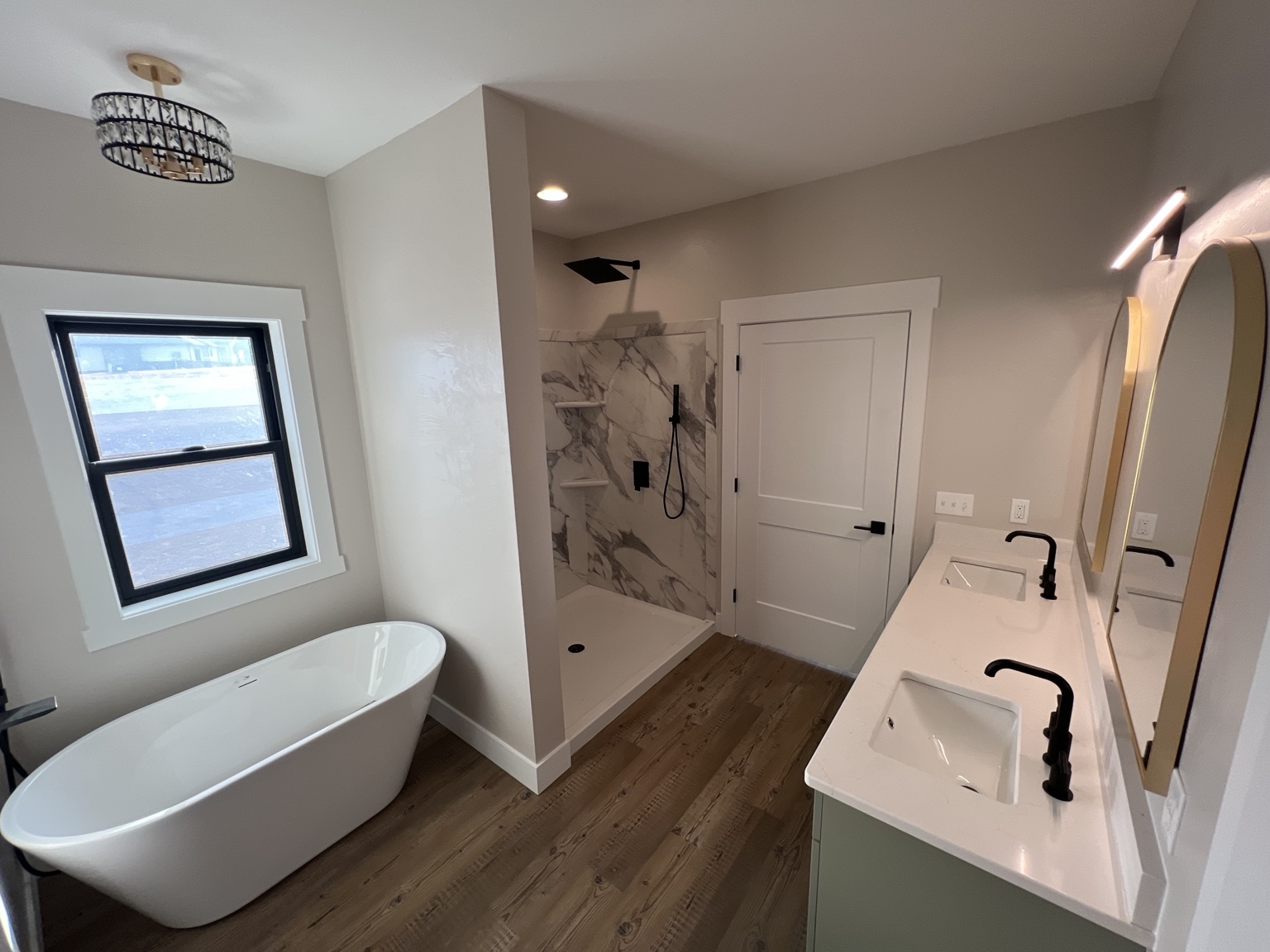 Finished custom primary bathroom with freestanding tub and double vanity